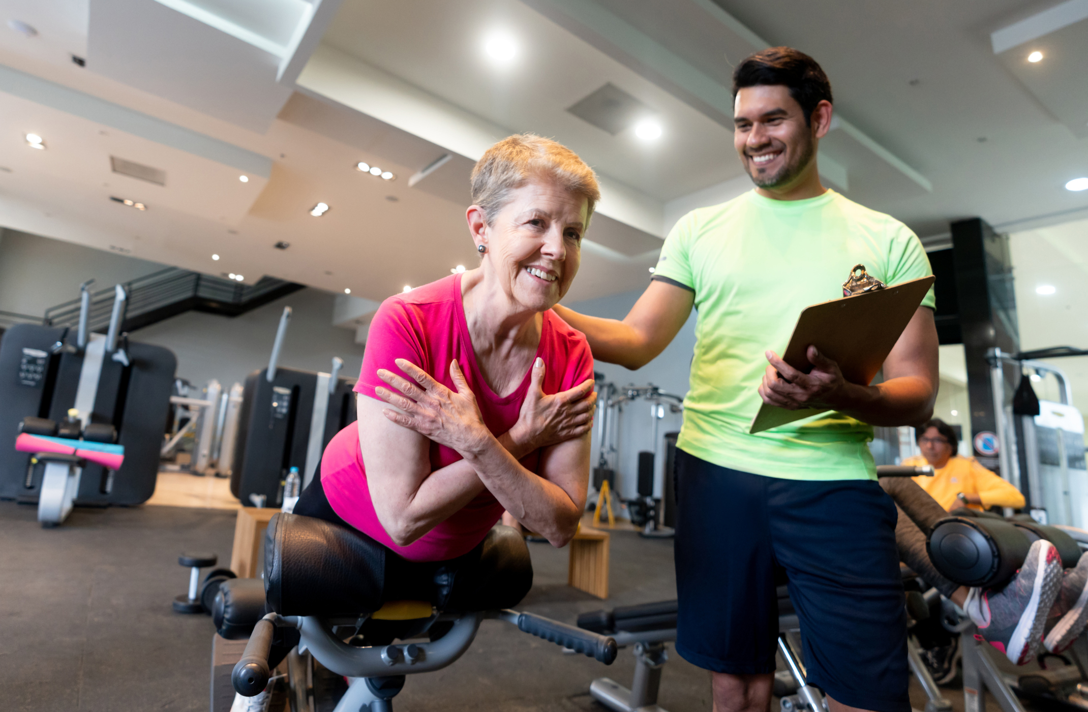 Senior woman exercising at the gym with a personal trainer